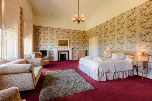 a bedroom with two beds and a fireplace at Cheviot Manor in Wooler