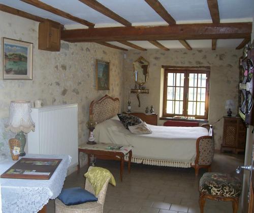 a bedroom with a bed and a table and a couch at Maison d'Hôtes Les Après in Bellême