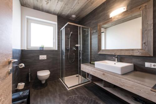 a bathroom with a sink and a shower and a toilet at Haus Wiesenstein in Lana