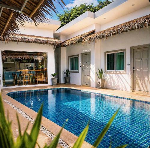 a swimming pool in front of a house at jungle pad accomodation in Rawai Beach