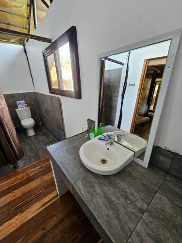 a bathroom with a sink and a mirror at Binga Beach Resort in San Miguel