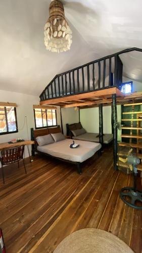 a living room with a bed and a loft bed at Binga Beach Resort in San Miguel