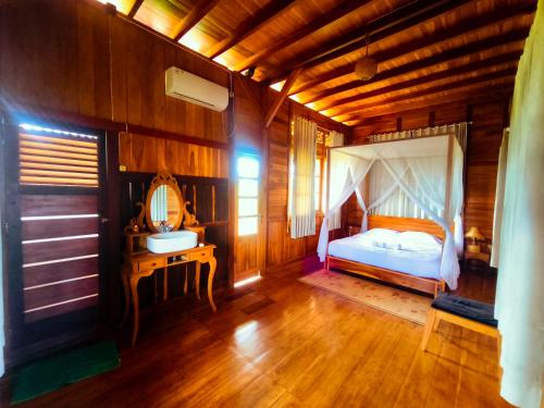 a bedroom with a bed and a desk in a room at 361 Alam in Tetebatu