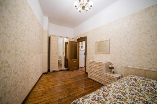 a bedroom with a bed and a dresser and a mirror at Seaside house in Liepāja