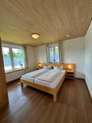 a bedroom with a large bed and two windows at Schwarzwaldhotel Schmitz in Todtmoos