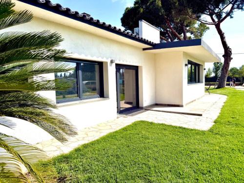 a white house with a green lawn at Villa Escaldes in Montroig