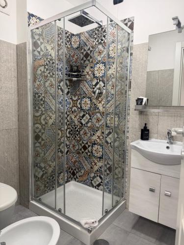 a bathroom with a shower with a toilet and a sink at ALDIVA ROOMS in Torvaianica