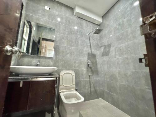 a small bathroom with a sink and a toilet at Blooming Inn in Gurgaon