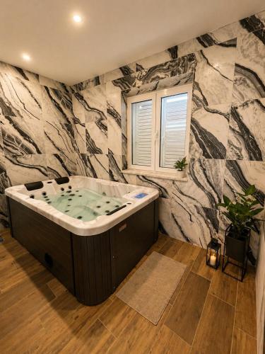 a bath tub in a bathroom with a stone wall at Centrium Makarska in Makarska