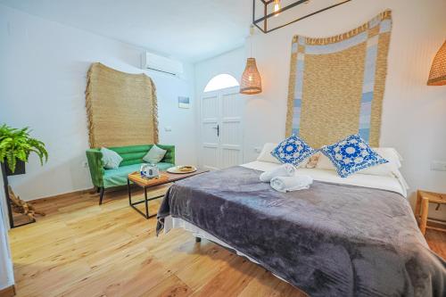 a bedroom with a bed and a green chair at Blancos Rooms Hotel in Peniscola
