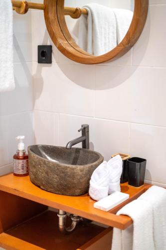 a bathroom with a sink and a mirror on a shelf at Lala Panzi Villa by Manara in Jimbaran