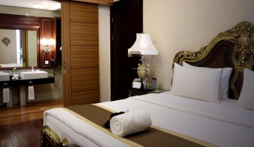 a bedroom with a bed and a bathroom with a sink at Java Palace Hotel in Cikarang