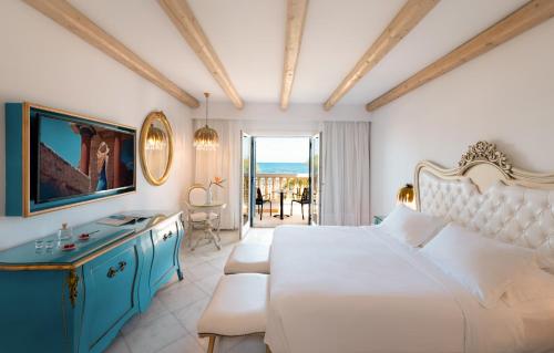 a bedroom with a white bed and a blue cabinet at Mitsis Selection Laguna in Hersonissos