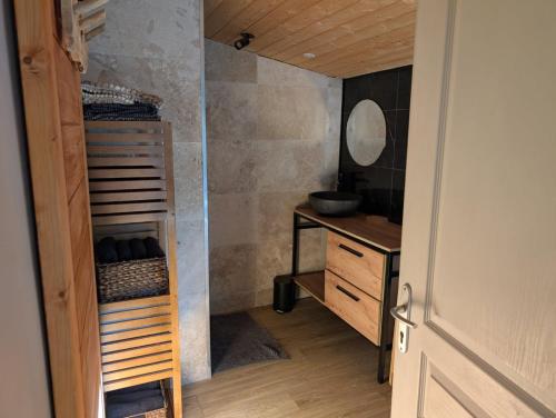 a bathroom with a sink and a vanity and a mirror at Gite Chez Tof et Ninie in Houlle