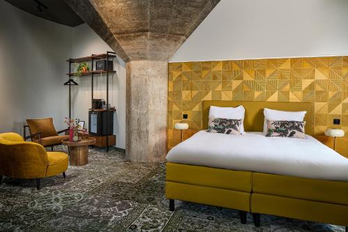 a bedroom with a bed and a yellow wall at Hotel Restaurant Grandcafé 't Voorhuys in Emmeloord
