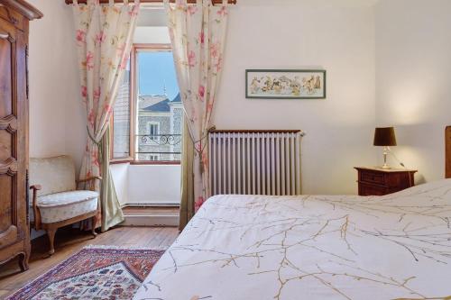 a bedroom with a bed and a window at Maison des papillons Daglan in Daglan