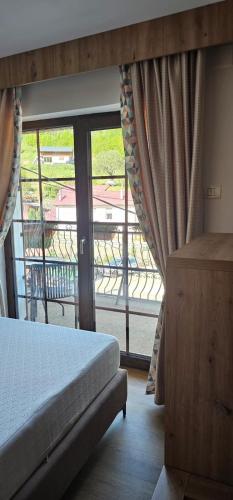 a bedroom with a bed and a large window at Casa Caius in Văliug