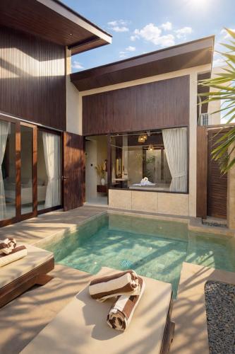 a house with a swimming pool and a villa at Eden Villas Lombok in Kuta Lombok