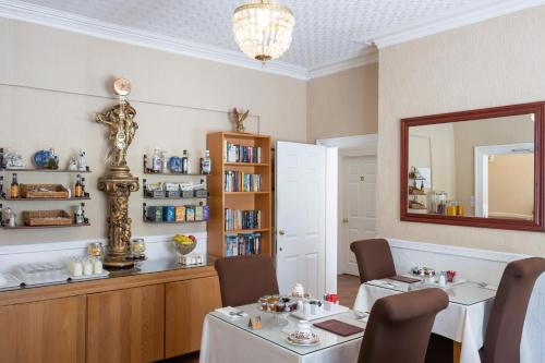 a dining room with two tables and a mirror at Diadem Hotel in Great Yarmouth