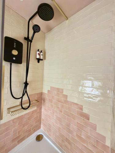 a bathroom with a shower with pink tiles at The Old Feed Store in Okehampton