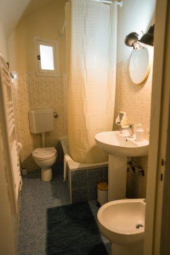 a bathroom with a sink and a toilet and a mirror at L'abbraccio in Dolceacqua
