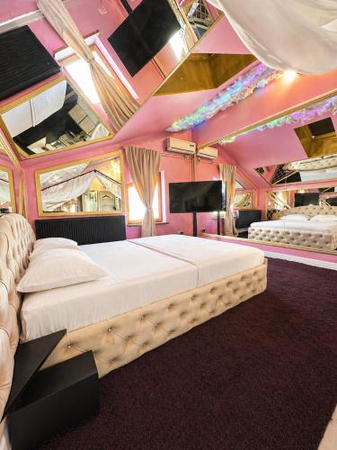 a bedroom with a large bed and a flat screen tv at Hotel Boutique18plus - Adults Only in Mamaia Sat/Năvodari