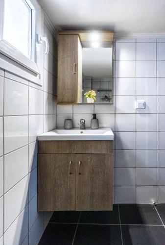 a bathroom with a sink and a mirror at Elysian Hightower in Thessaloniki