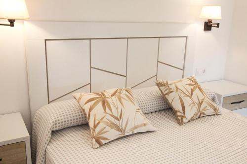 a bedroom with a bed with two pillows on it at Apartamentos Los Novalejos in Arnuero