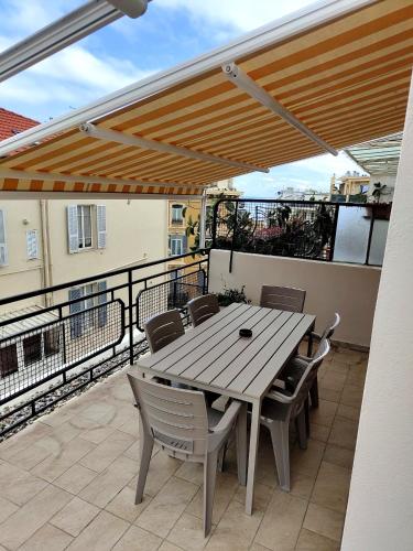 a wooden table and chairs on a patio at Attico Matteotti Sanremo Luxury Terrace Apartment in Sanremo