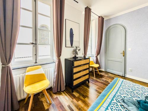 a bedroom with a bed and a dresser and a window at Chic Bastide in Carcassonne