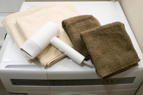 a pile of towels on top of a washing machine at NOW Onomichi in Onomichi