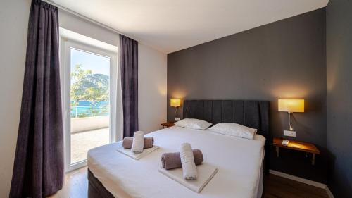 a bedroom with a bed and a large window at Villa Estera by Villas Guide in Ston