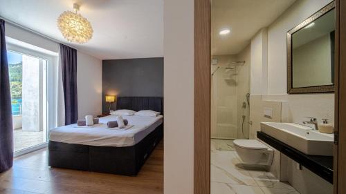 a bedroom with a bed and a sink and a bathroom at Villa Estera by Villas Guide in Ston
