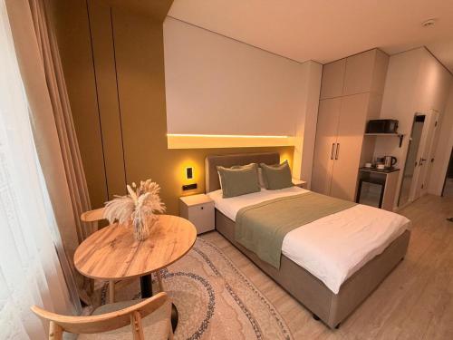 a bedroom with a bed and a wooden table at Sea Star Boutique Hotel in Almaty