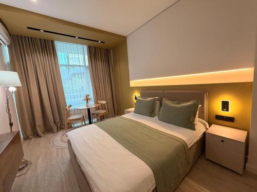 a hotel room with a large bed and a table at Sea Star Boutique Hotel in Almaty