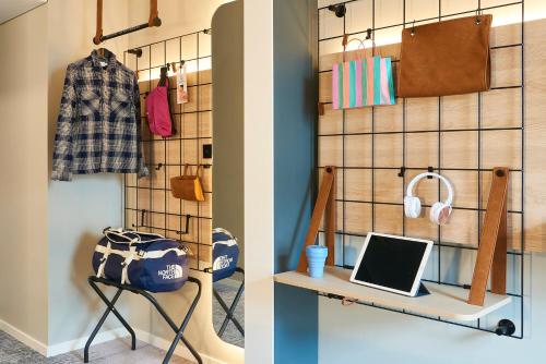 a closet with a desk and a laptop on a shelf at Moxy Essen City in Essen