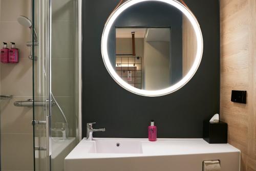a bathroom with a sink and a mirror at Moxy Essen City in Essen