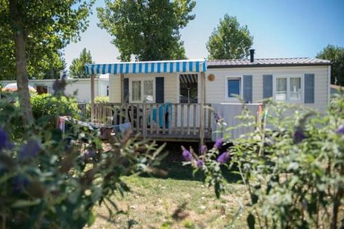 a small white house with a blue roof at ZEcamping 4 étoiles pet friendly terrain multisports piscine couverte in Angles