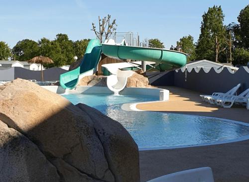 a swimming pool with a water slide in a resort at ZEcamping 4 étoiles pet friendly terrain multisports piscine couverte in Angles