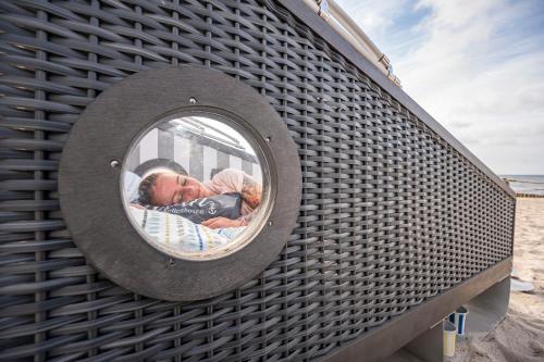 a reflection of two people in a round mirror at Schlafstrandkorb Nr 5 in Kellenhusen