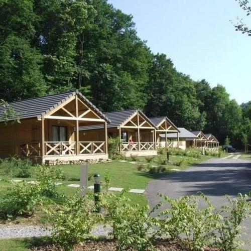 a row of wooden lodges with trees in the background at ZEcamping 4 étoiles familial pet friendly animé piscine chauffée in Aramits
