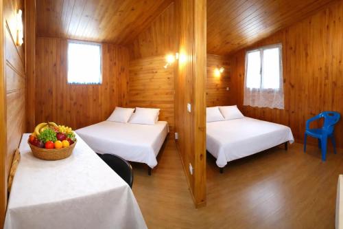 a room with two beds and a bowl of fruit at ZEcamping 3 étoiles familial avec Piscine et Bar-restaurant in Saint-Honoré-les-Bains