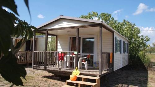 a tiny house with a porch and a deck at ZEcamping 3 étoiles chiens acceptés piscine bar et restaurant in Mézel