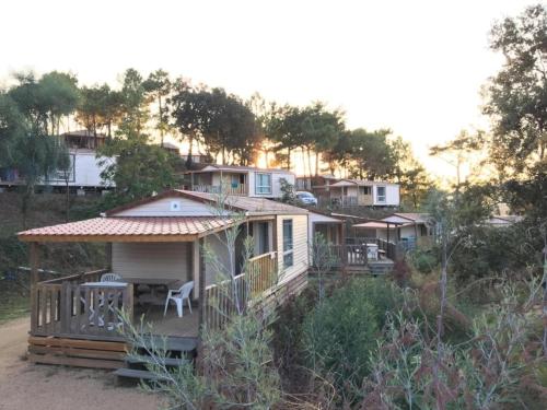 a small house with a porch and a deck at ZEcamping 3 étoiles à 1km de la plage piscine jacuzzi animaux acceptés in Viggianello