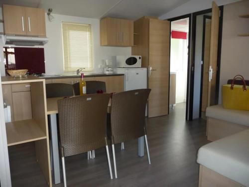 a kitchen with a table and chairs in a room at ZEcamping 4 étoiles familial animaux acceptés familial piscine couverte in Aureilhan
