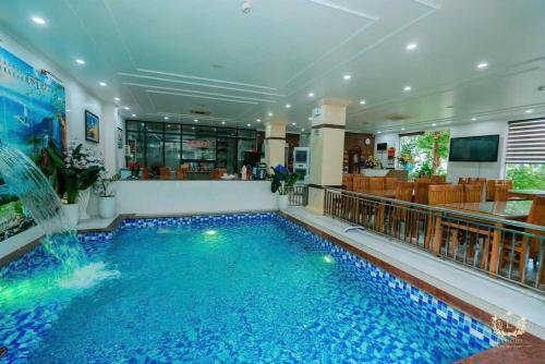 a large swimming pool with a fountain in a building at Ks Luxhotel flc sầm sơn in Sầm Sơn