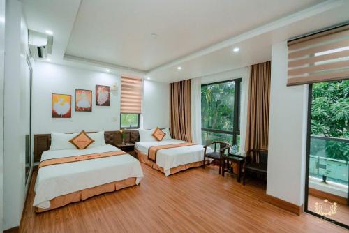 a hotel room with two beds and a couch at Ks Luxhotel flc sầm sơn in Sầm Sơn