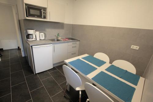 a kitchen with a table and chairs and a sink at Fewo-Baunatal / Ferienwohnung "Am Pilgerbach" in Baunatal