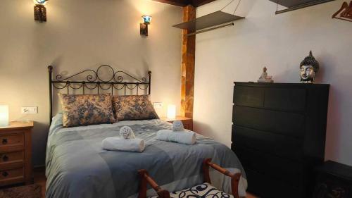 a bedroom with a large bed with towels on it at El callejón del Santo in Ubrique