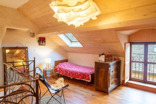 a bedroom in a log cabin with a bed and a chandelier at Chez mamiethé in Ispagnac